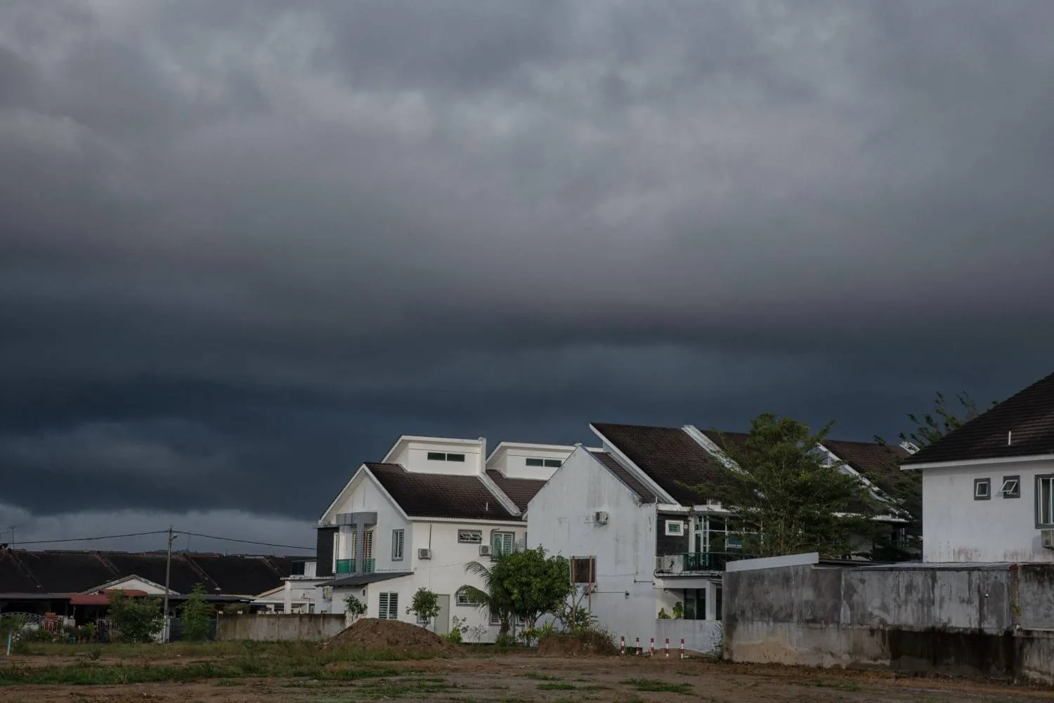 Storm clouds building over a row of rooftops