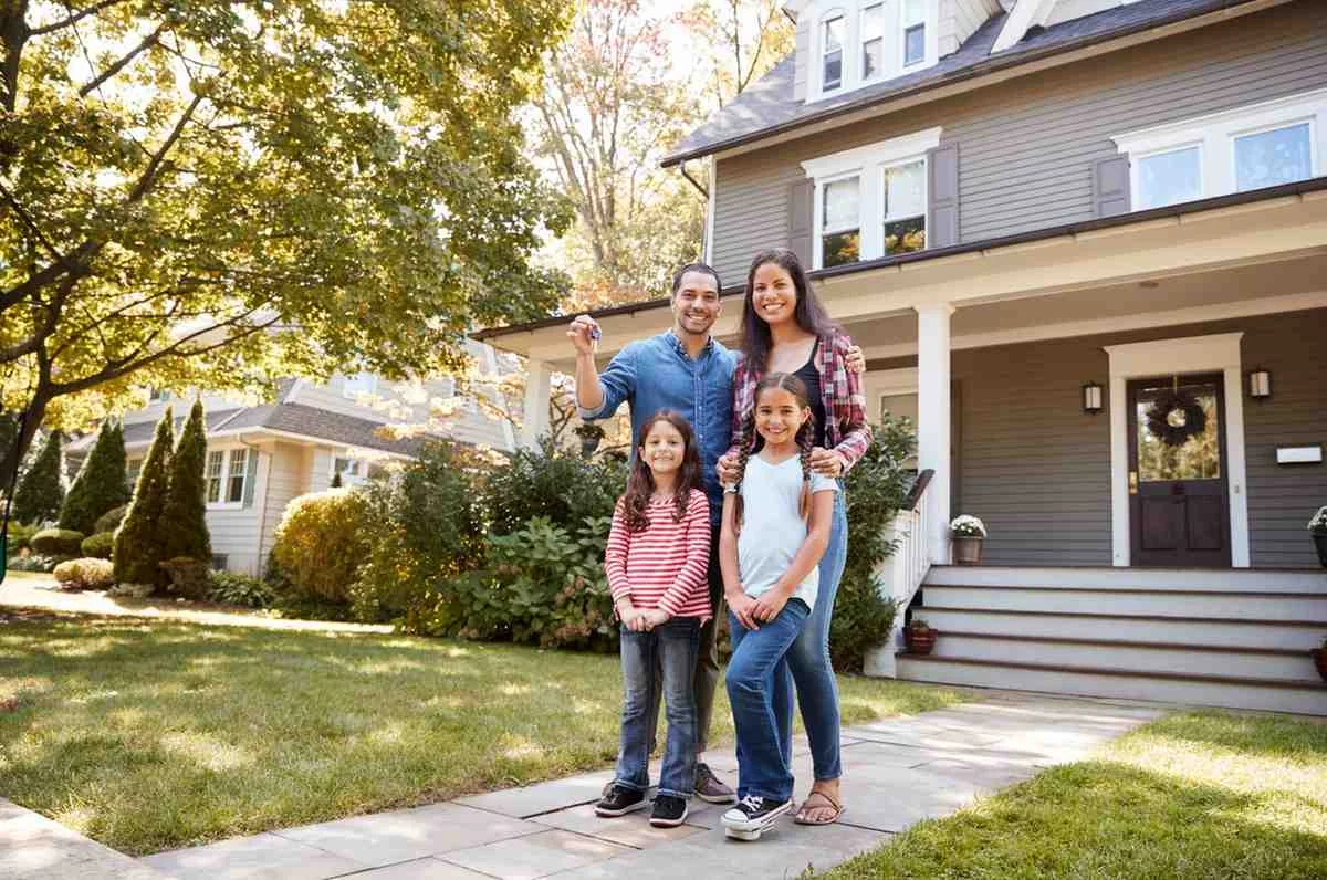 Family standing outside their home holding the keys